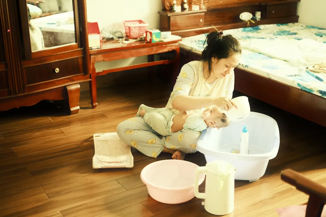 집에서 아기를 씻기는 엄마 — 물사마귀 가정 관리와 위생을 설명하는 이미지